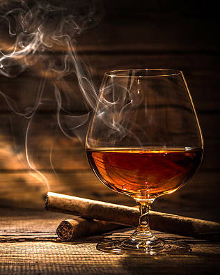 Glass of whiskey with smoking cigar and ice cubes on wooden table
